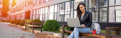 Junge Frau mit Laptop vor moderner Kulisse – Symbolbild für das KMS Ausbildungsforum 2026 in Krefeld