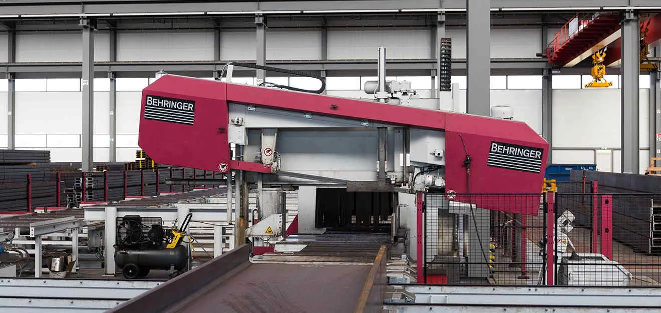 Behringer-Sägemaschine in Produktionshalle; Förderbahn zum Sägekopf, Geländer und Geräte