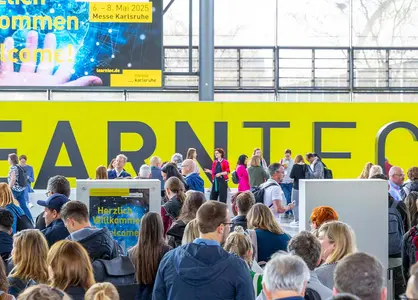 LEARNTEC 2025 in Karlsruhe: Eingang Besucher Menschenmenge am Eingang der LEARNTEC 2025 in Karlsruhe vor gelber Wand mit Schriftzug