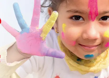 Kinderkrebsstiftung. Freundliches Mädchen mit bunten Händen und geschminktem Gesicht.