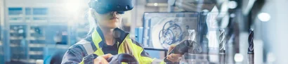 unitop für Industrieunternehmen – Produktion und Planung transparent steuern Symbolbild: Person mit VR-Brille in der Fertigung, CAD-Ansicht am Monitor und Werkzeuge im Fokus.