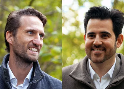 Zwei lächelnde Männer im Porträt vor unscharfem grünen Hintergrund.