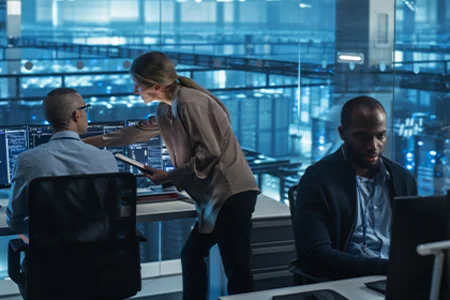 Symbolbild: Expertenteam analysiert IT-Systeme an Monitoren in einem Leitstand.