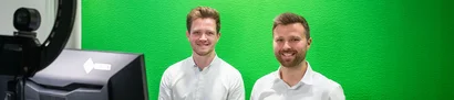 Webinar Microsoft 365 Copilot im NPO-Alltag: Vortragende | 1905 x 425 Pixel Daniel Heuhsen und Moritz Eichenauer im Webinar zu Microsoft 365 Copilot für NPOs vor grünem Screen