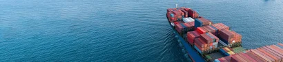 Containerschiff mit bunten Frachtcontainern auf offener See als Symbol für den technischen Handel.