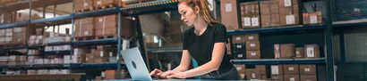 Cloud-ERP-Systeme – geräte- und ortsunabhängig einsetzbar | 1905 x 425 Pixel Mitarbeiterin in der Logistik arbeitet mit ERP-System am Laptop zur Lagerbestandsverwaltung.