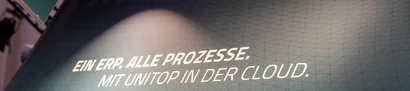 LogiMAT 2026: unitop-Claim am GOB-Stand Schriftzug „Ein ERP. Alle Prozesse. Mit unitop in der Cloud.“ auf Messewand am GOB-Stand.