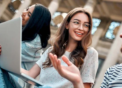Campusmesse Düsseldorf 2025 Studierende im Gespräch auf einem Universitätscampus, mit Laptop und Smartphone, entspannt im Freien