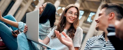 Campusmesse Düsseldorf 2025 Studierende im Gespräch auf einem Universitätscampus, mit Laptop und Smartphone, entspannt im Freien