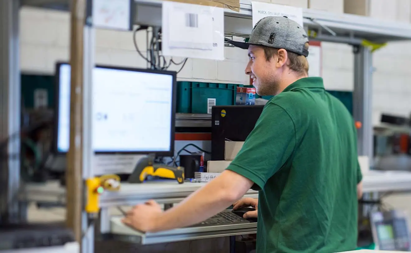 Lederer-Lagerlogistik-Mitarbeiter am PC Mitarbeiter der Lederer GmbH prüft Daten im Lagerverwaltungssystem an einem Arbeitsplatz.