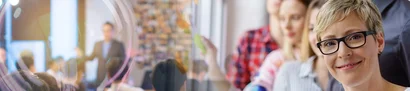 Seminarraum: Personen arbeiten, blonde Seminarleiterin im Vordergrund.