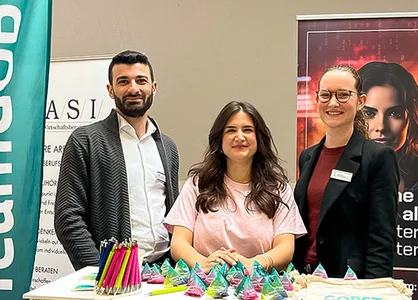 Das GOB-Recruiting-Team steht vor Roll-ups am Messestand der Campusmesse Düsseldorf.