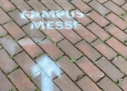 Wegweiser auf HHU-Campus: Weißer Pfeil auf roten Pflastersteinen zeigt den Weg zur Campusmesse Düsseldorf 2024 Headerbild weißer Pfeil auf roten Pflastersteinen zeigt Weg zur Campusmesse Düsseldorf 2024