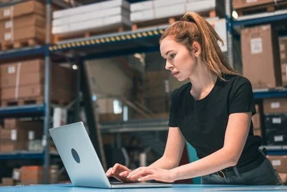 Cloud-ERP-Systeme – geräte- und ortsunabhängig einsetzbar Mitarbeiterin in der Logistik arbeitet mit ERP-System am Laptop zur Lagerbestandsverwaltung.