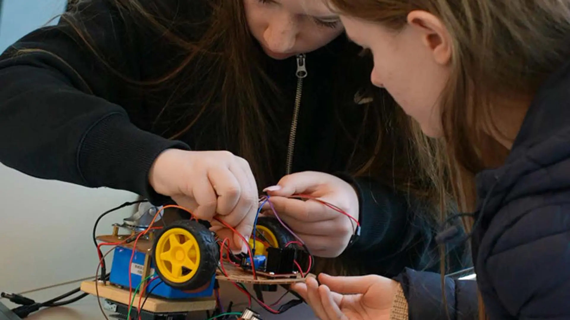 Zwei Teilnehmerinnen des Girls'Day 2025 verkabeln konzentriert ihren Arduino-Roboter in der GOB.
