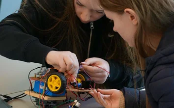 Zwei Teilnehmerinnen des Girls'Day 2025 verkabeln konzentriert ihren Arduino-Roboter in der GOB.