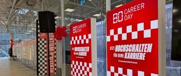 Eingangsbereich mit roten BO Career Day-Tafeln, kariertem Design und Luftballons