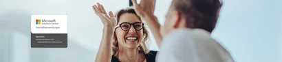 Microsoft Solutions Partner für Geschäftsanwendungen – Spezialisierung „Verwaltung kleiner und mittelständischer Unternehmen“ erneuert Zwei Personen im Büro beim High-Five, links Logo Microsoft Solutions Partner KMU-Verwaltung.