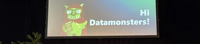 Begrüßung auf der SQL-Konferenz 2026 in Hanau – „Hi Datamonsters!“ Leinwand zeigt Folie „Hi Datamonsters!“ mit grüner Monsterfigur bei der SQL-Konferenz 2026.