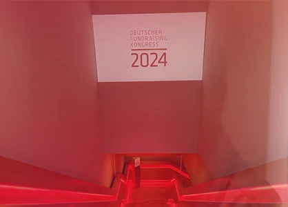 Rot beleuchtete absteigende Treppe führt zum Deutschen Fundraising Kongress 2024 Rückblick Deutscher Fundraising Kongress 2024: Rot beleuchtete Treppe zum DFK 2024