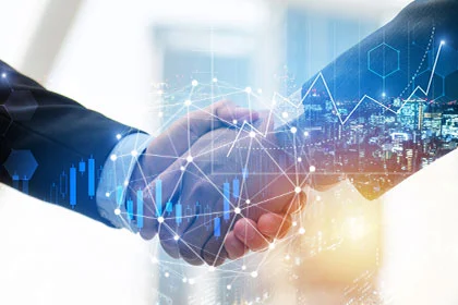 Two businesspeople shaking hands in front of a digital background with data and charts.
