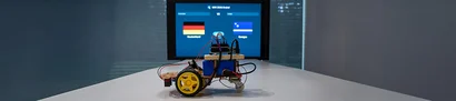 KI trifft Arduino beim WM-Orakel Arduino-Roboter steht vor einem Bildschirm mit dem WM-Orakel 2026.