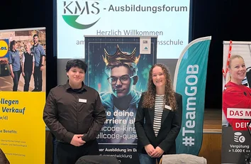 Zwei GOB-Mitarbeitende am Messestand auf dem KMS-Ausbildungsforum vor Bannern und Roll-ups.