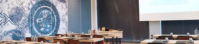 Modern eingerichteter Konferenzraum mit Tischen, Stühlen und kunstvoller Wanddekoration