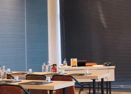 Modern eingerichteter Konferenzraum mit Tischen, Stühlen und kunstvoller Wanddekoration