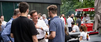 GOB-Mitarbeitende unterhalten sich beim GOB RUN & FUN und Juni-Sundowner 2026 im Außenbereich.