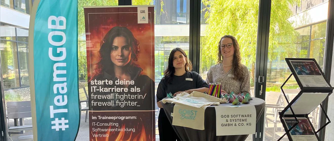 Das GOB-Recruiting-Team auf der „Ich lach’ mich Job“ 2026 GOB-Stand: Zwei GOB-Recruiting-Kolleginnen stehen am Infotisch, #TeamGOB-Flagge und Karriereplakat.