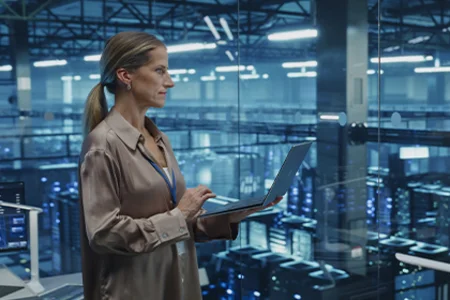 Symbolbild: Auditorin prüft Systeme im Rechenzentrum am Laptop für ein Sicherheitsaudit.