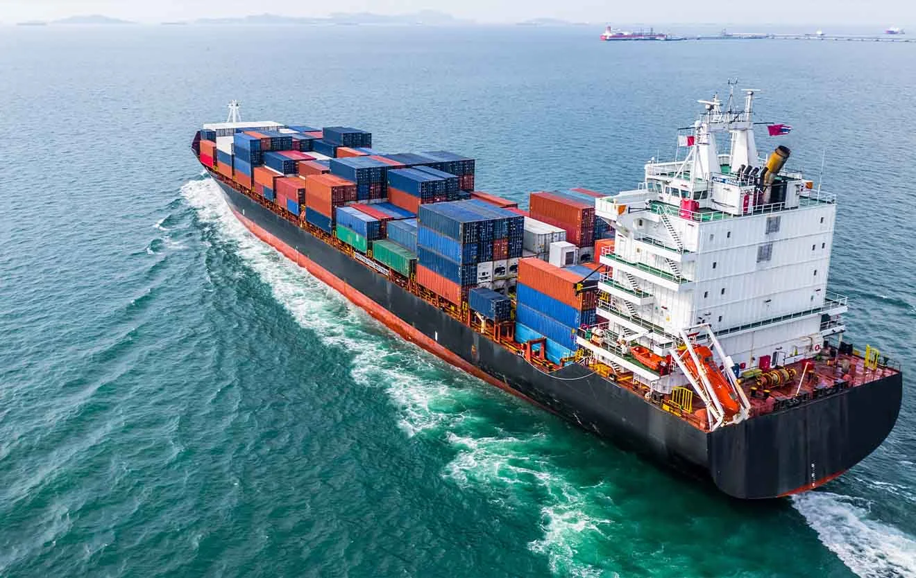 Containerschiff mit bunten Frachtcontainern als schwimmende Ware auf dem Meer.