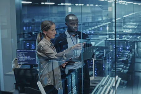 Potenziale erkennen, Lösungen entwickeln – mit unserer KI-Beratung Symbolbild: Zwei Personen mit Laptop vor Serverracks hinter Glas – KI-Beratung der GOB beim Kunden.