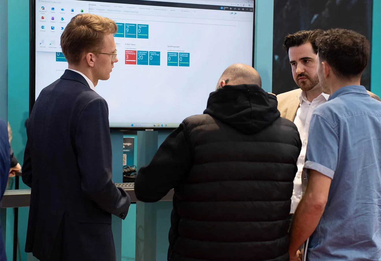 Besuchergruppe am GOB-Stand der LogiMAT 2026 vor Bildschirm mit unitop-Dashboard und Kennzahlen.