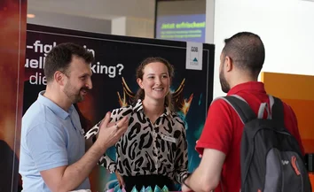 Gökay Sevgi und Laureen Bartholemy im Gespräch mit Besucher am GOB-Stand der RUB Karrieremesse 2025