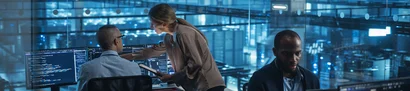 IT security consultancy: identifying risks, strengthening security Symbolic image: A team of experts analysing IT systems on monitors in a control room.