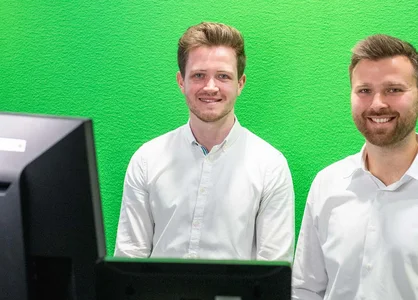 Webinar Microsoft 365 Copilot im NPO-Alltag: Vortragende | 1920 x 780 Pixel Daniel Heuhsen und Moritz Eichenauer im Webinar zu Microsoft 365 Copilot für NPOs vor grünem Screen.