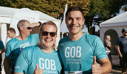 GOB beim Run & Fun – Aufnahme aus 2024, Vorfreude auf den Lauf 2025 Zwei GOB-Kollegen – eine Frau und ein Mann – strahlen beim Run & Fun 2024 in Krefeld in die Kamera