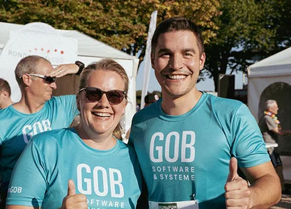 GOB beim Run & Fun – Aufnahme aus 2024, Vorfreude auf den Lauf 2025 Zwei GOB-Kollegen – eine Frau und ein Mann – strahlen beim Run & Fun 2024 in Krefeld in die Kamera