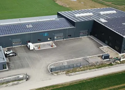 Luftaufnahme Fischer-EKF-Firmengebäude mit Solaranlagen auf dem Dach & Parkplatz umgeben von Feldern