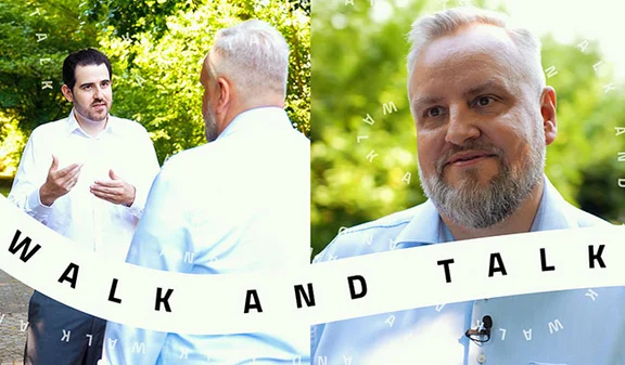 Zwei Männer im Gespräch bei „Walk and Talk“-Format im Grünen, rechte Bildhälfte mit Porträtaufnahme
