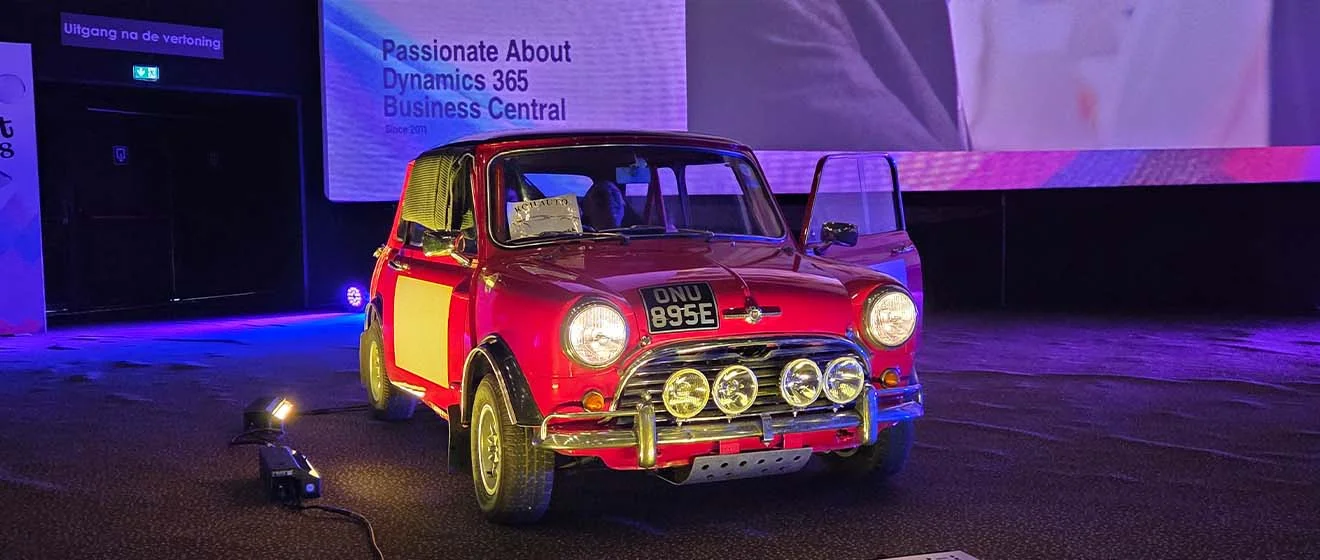 Roter klassischer Mini auf der Bühne vor einer Projektion zu Dynamics 365 Business Central.
