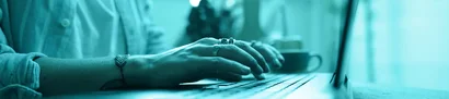 Person tippt konzentriert auf Laptop und recherchiert in entspannter Atmosphäre