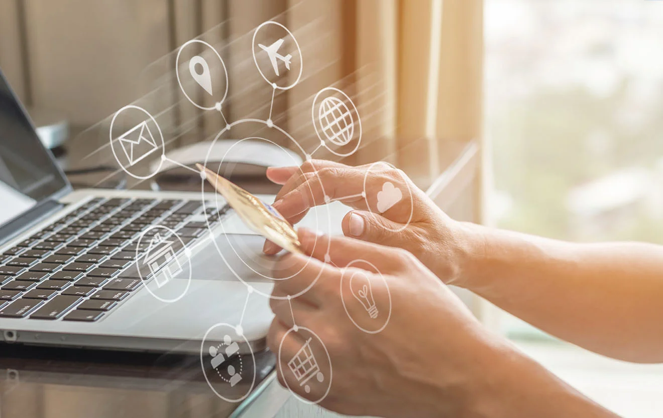 Online-Zahlung im Multichannel-E-Commerce – vernetzt mit dem ERP-System Hände halten eine Zahlungskarte vor Laptop und Smartphone, darüber Symbole für Onlinehandel.