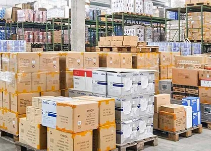 Logistik-Halle von Gerd van Well mit hochgestapelten Geschirrkartons und zwei Lagermitarbeitern