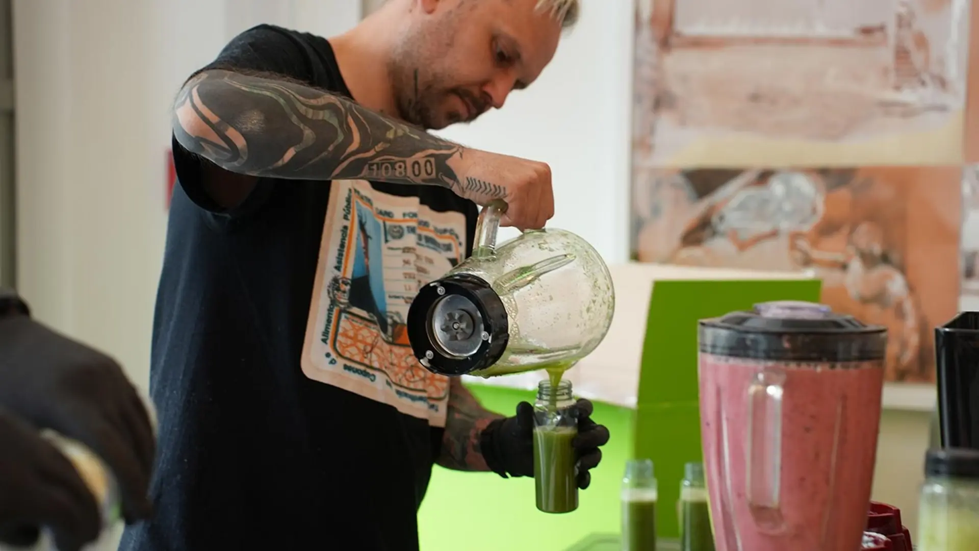Tätowierter Kellner füllt grünen Smoothie bei der RUB Karrieremesse 2025 in einen Trinkbecher ab