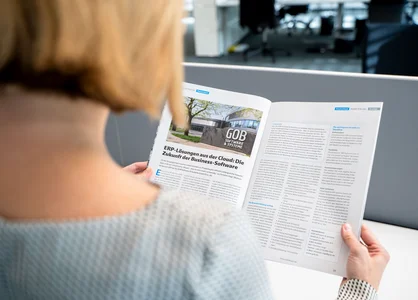 Blonde Frau liest GOB-Artikel in Stahlmarkt-Magazin Oktober/November 2023