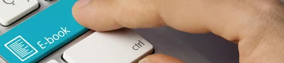 Nahaufnahme einer Computertastatur mit blauem E-Book-Button und darauf zeigendem Finger