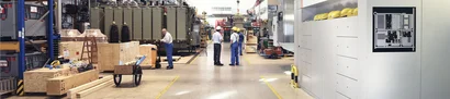 Panoramablick in eine Fertigungshalle aus dem Maschinenbau mit Anlagen, Werkstücken und Fachkräften.